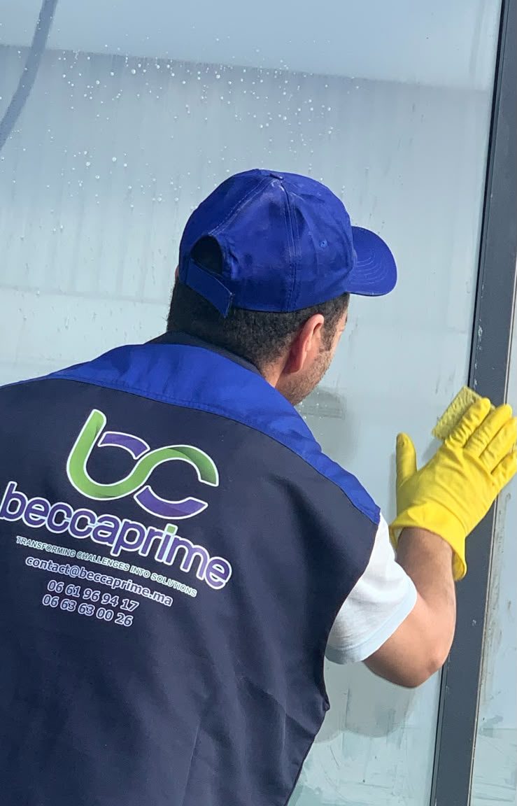 Agent Beccaprime nettoyant une vitre à la main